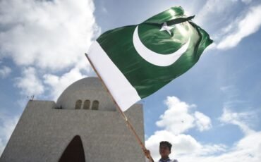 TOPSHOT - A student waves the national flag of Pakistan outside the mausoleum of country's founder Mohammad Ali Jinnah, after Pakistan's 75th Independence Day ceremony in Karachi on August 14, 2022. (Photo by Rizwan TABASSUM / AFP) (Photo by RIZWAN TABASSUM/AFP via Getty Images)